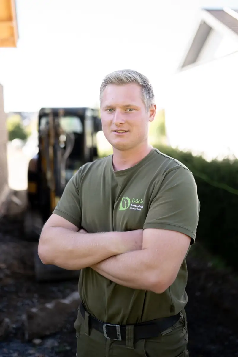 Peter Dück, Geschäftsführer von Dück Gartenpflege/Gartenbau, mit verschränkten Armen auf einer Baustelle
