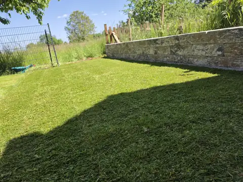 Rasenfläche vor Natursteinmauer