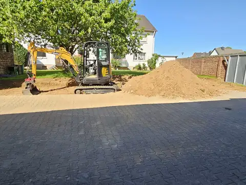 Erdarbeiten neben neuer Pflasterfläche